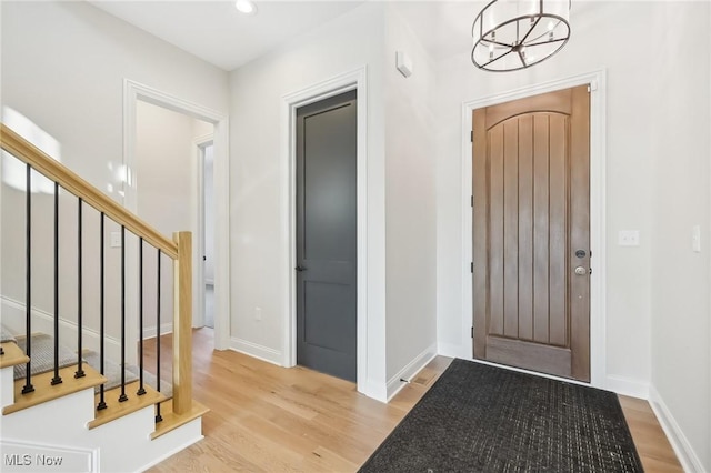 foyer with an inviting chandelier and light hardwood / wood-style flooring