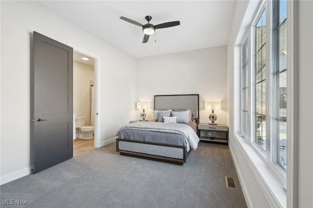 bedroom featuring ceiling fan, connected bathroom, and dark colored carpet