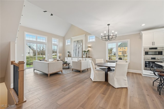 dining area featuring light hardwood / wood-style flooring, a wealth of natural light, and a chandelier