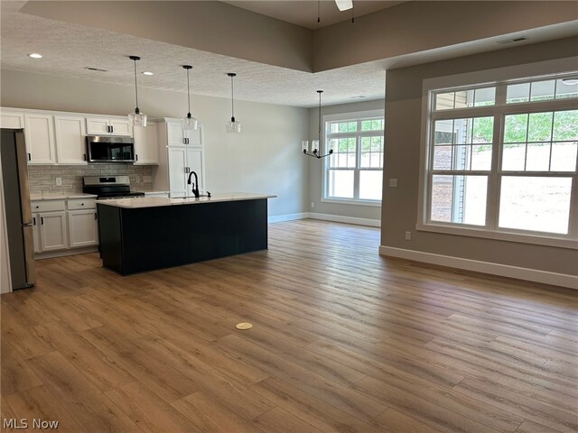944 Queen Anne Dr NW, Massillon, OH 44647 - kitchen featuring pendant lighting, stainless steel appliances, and hardwood / wood-style flooring