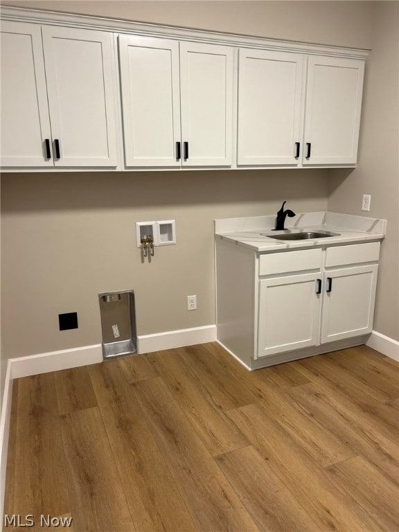 944 Queen Anne Dr NW, Massillon, OH 44647 - washroom featuring hookup for a washing machine, light hardwood / wood-style floors, cabinets, and sink