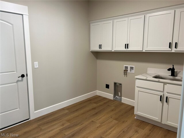 944 Queen Anne Dr NW, Massillon, OH 44647 - laundry room with wood-type flooring, cabinets, sink, and washer hookup