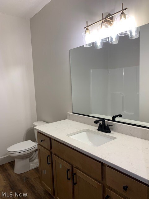 bathroom with hardwood / wood-style floors, vanity, and toilet