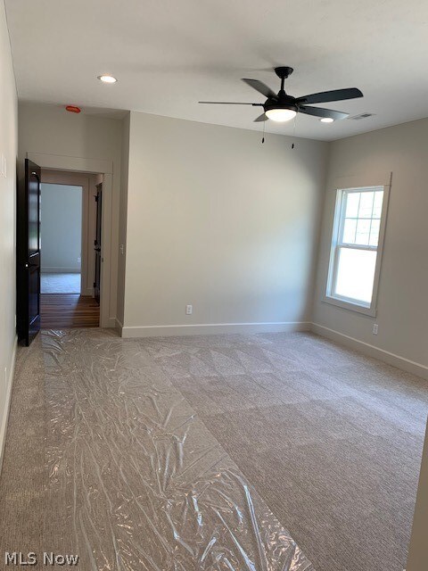 spare room with carpet flooring and ceiling fan