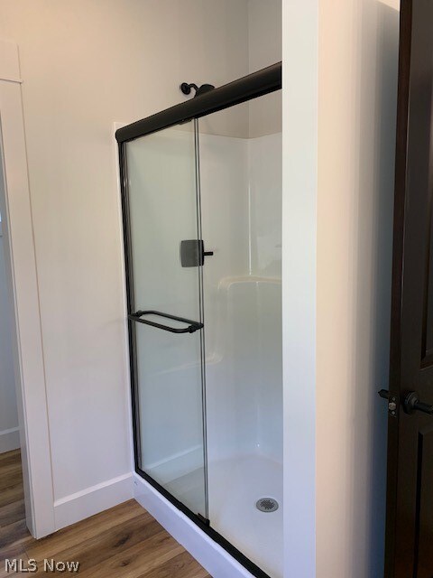 bathroom featuring hardwood / wood-style flooring and an enclosed shower