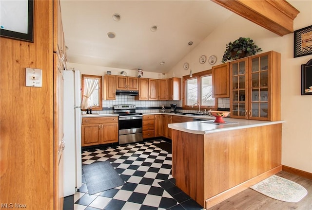 kitchen with sink, white refrigerator, kitchen peninsula, vaulted ceiling, and stainless steel range with electric stovetop