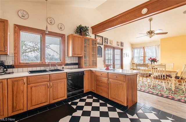 kitchen featuring kitchen peninsula, tasteful backsplash, sink, dishwasher, and lofted ceiling