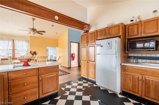 kitchen with white fridge, black microwave, ceiling fan, and dark wood-type flooring