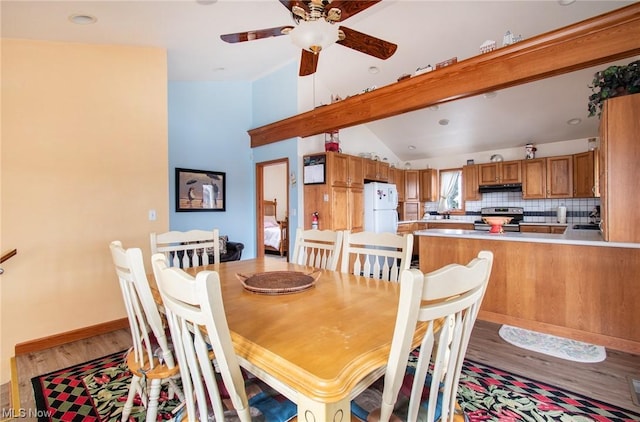 dining space featuring vaulted ceiling with beams, ceiling fan, light wood-type flooring, and sink