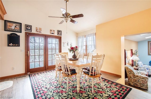 dining area with ceiling fan, light hardwood / wood-style floors, and vaulted ceiling