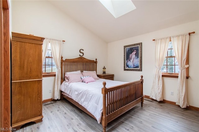 bedroom with light hardwood / wood-style floors and lofted ceiling with skylight