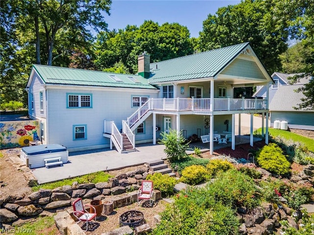 back of property with a patio and a hot tub