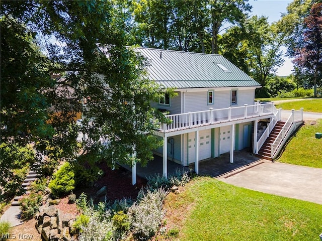 view of front of home with a garage, a wooden deck, and a front lawn