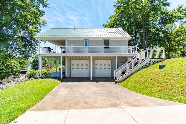 view of front of home featuring a front lawn, a porch, and a garage