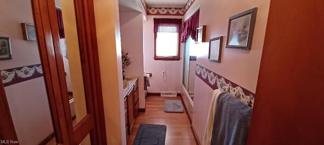 corridor with light hardwood / wood-style floors