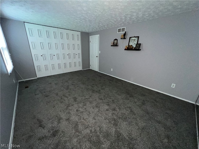 unfurnished bedroom with carpet flooring and a textured ceiling