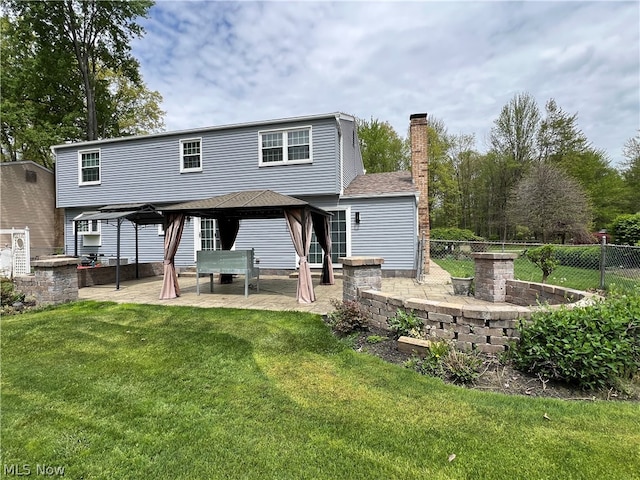 rear view of house featuring a patio and a lawn