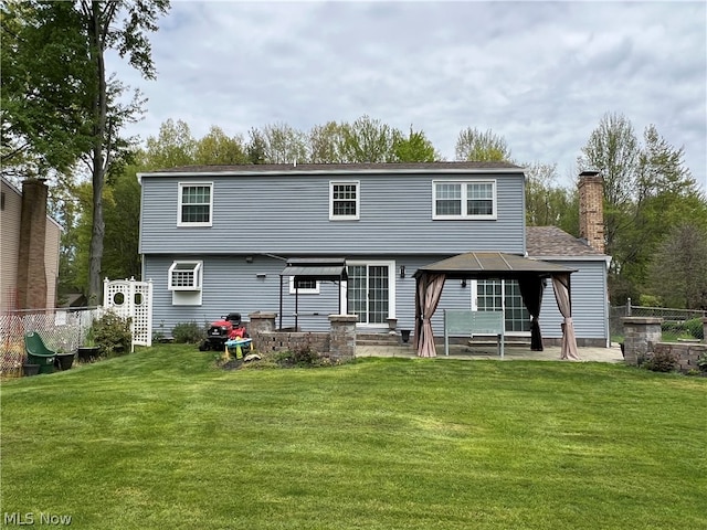 rear view of property featuring a patio area and a yard