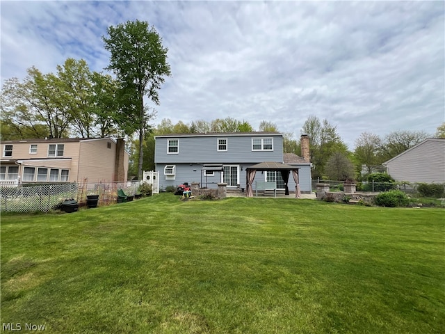 back of property with a patio area and a yard