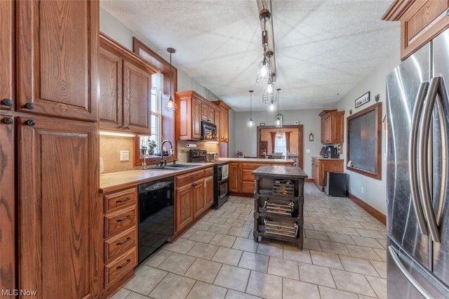 kitchen with a textured ceiling, black appliances, decorative light fixtures, sink, and light tile patterned floors