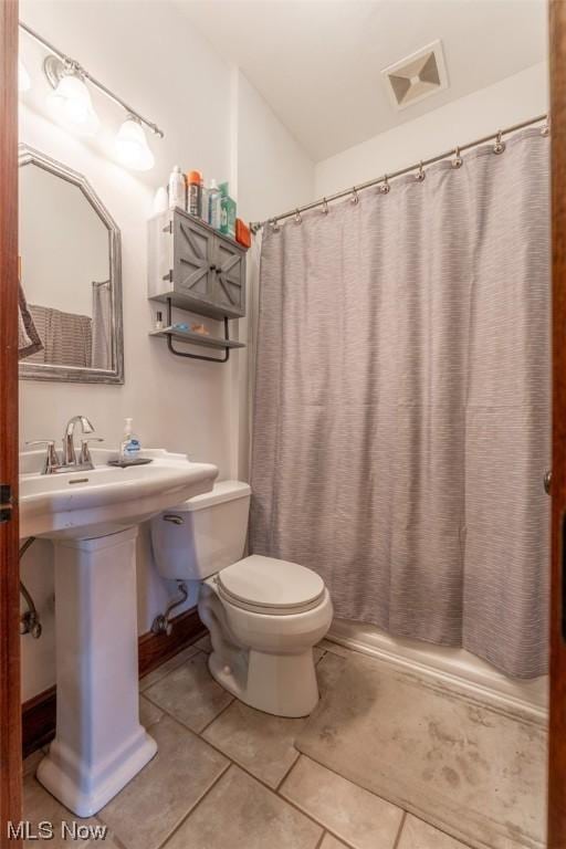 bathroom with toilet and tile patterned floors