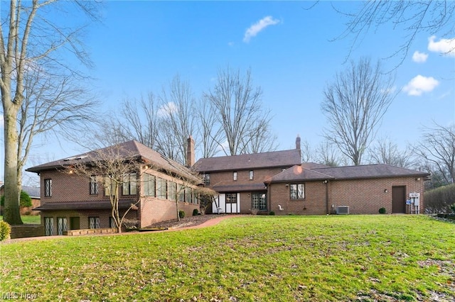 rear view of property featuring a sunroom, a yard, and central air condition unit