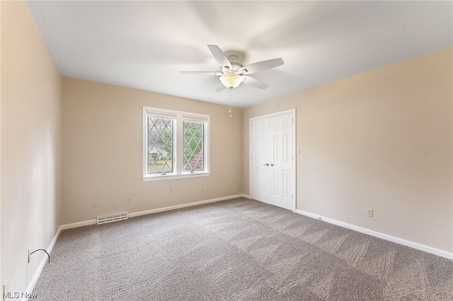 empty room with ceiling fan and carpet floors