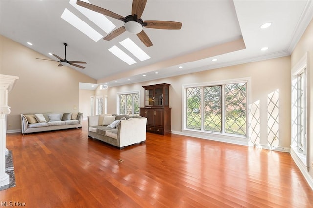 unfurnished living room featuring hardwood / wood-style floors, plenty of natural light, ceiling fan, and vaulted ceiling with skylight