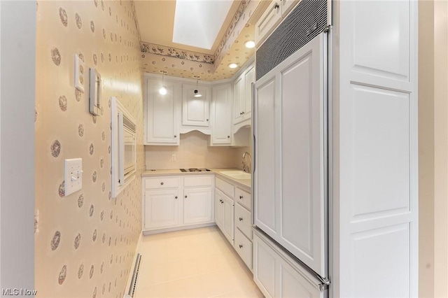 kitchen featuring decorative backsplash, sink, white cabinetry, and white gas stovetop