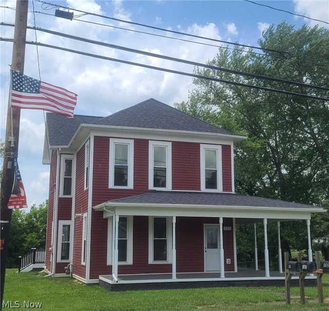 view of front of property featuring covered porch, a front lawn, and roof with shingles