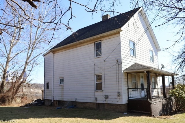 back of house with a lawn and a porch