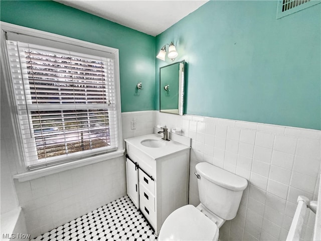 bathroom featuring tile walls, oversized vanity, toilet, and tile flooring