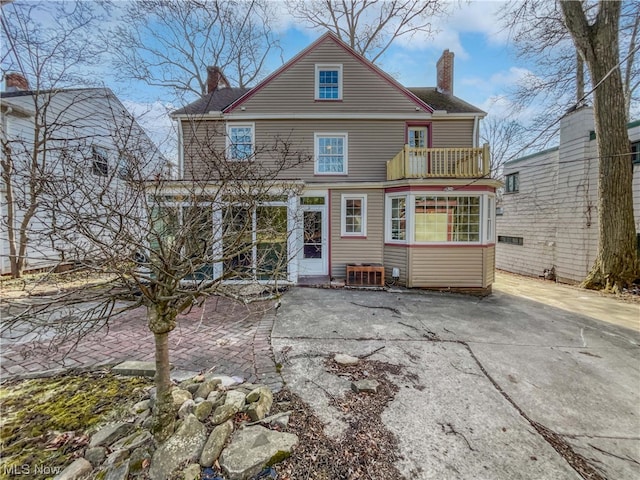 rear view of house with a balcony and central AC unit