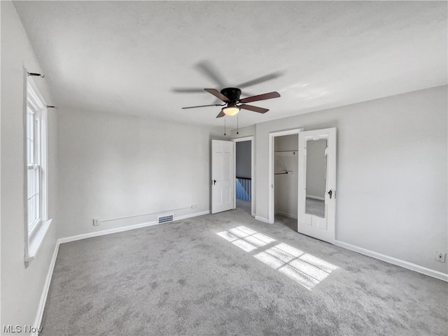 carpeted empty room with french doors and ceiling fan