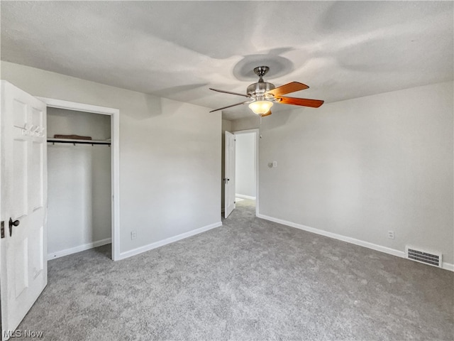 unfurnished bedroom with ceiling fan, light carpet, and a closet