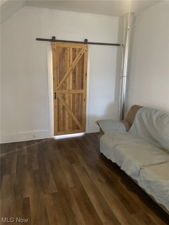 living area with a barn door and dark wood-type flooring