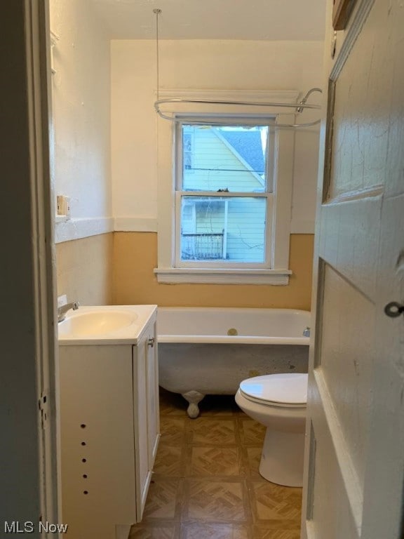 bathroom with toilet, vanity, and parquet floors