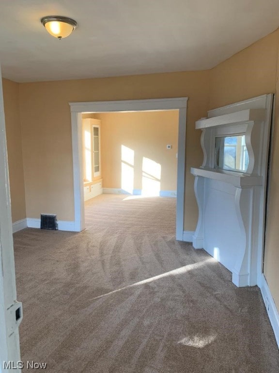 unfurnished room featuring light colored carpet