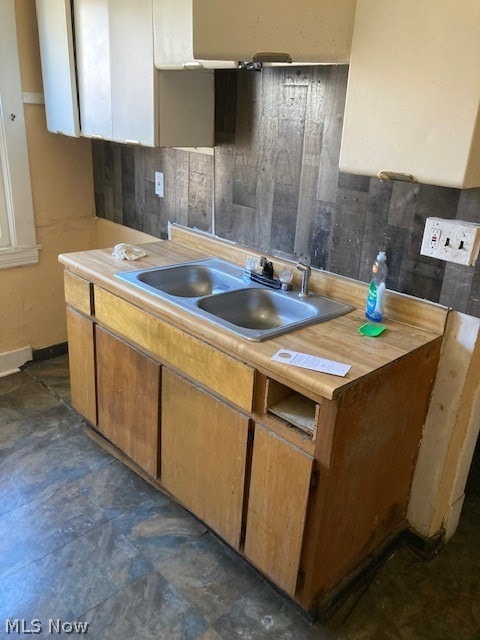 kitchen featuring dark tile flooring and sink