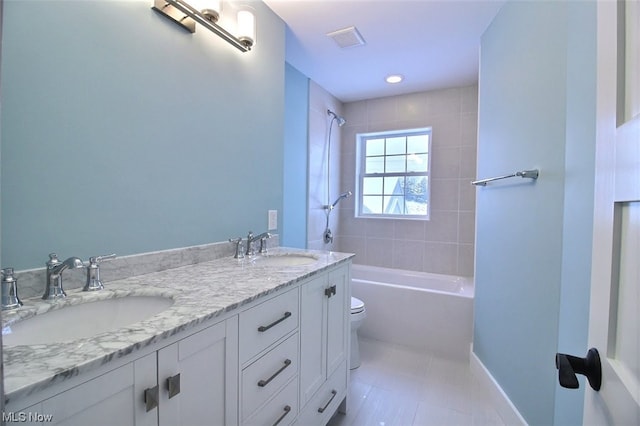 full bathroom featuring tiled shower / bath, vanity, toilet, and tile patterned floors