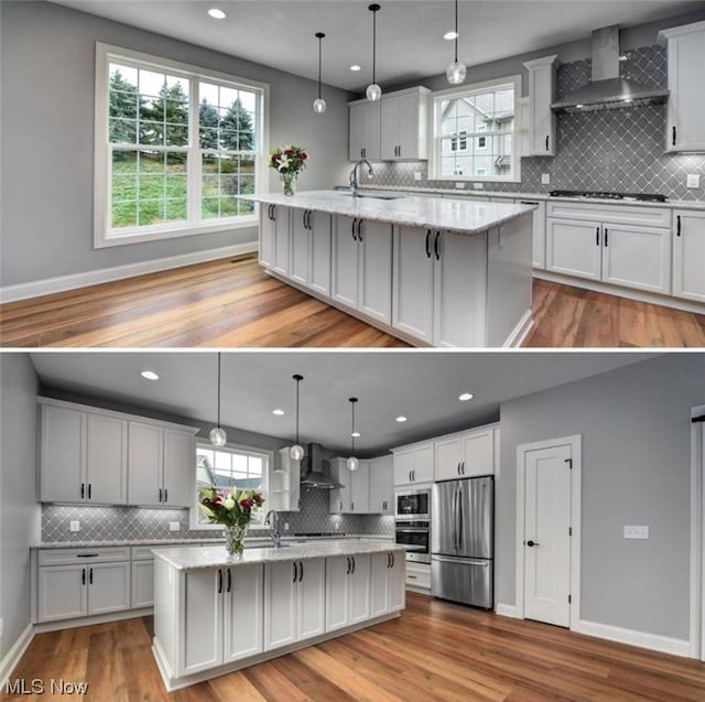 kitchen with wall chimney exhaust hood, a center island with sink, and appliances with stainless steel finishes