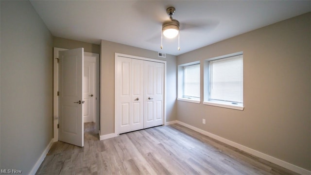 unfurnished bedroom featuring ceiling fan, a closet, and light hardwood / wood-style floors