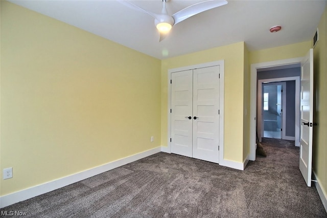 unfurnished bedroom featuring ceiling fan, dark carpet, and a closet