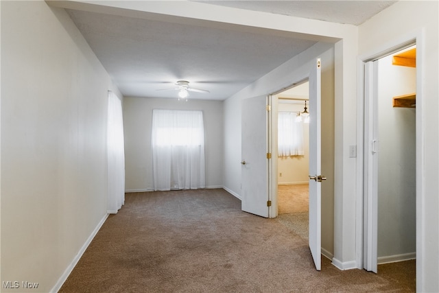 hall with a chandelier and carpet floors