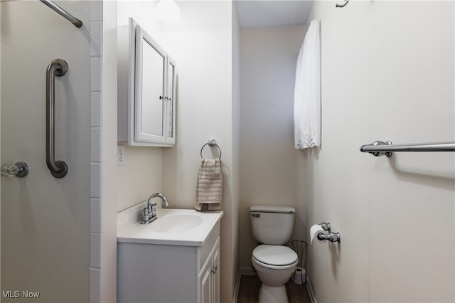 bathroom featuring walk in shower, vanity, and toilet