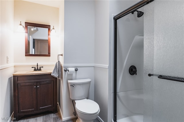 bathroom with vanity, hardwood / wood-style flooring, an enclosed shower, and toilet