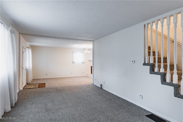 carpeted spare room with a notable chandelier