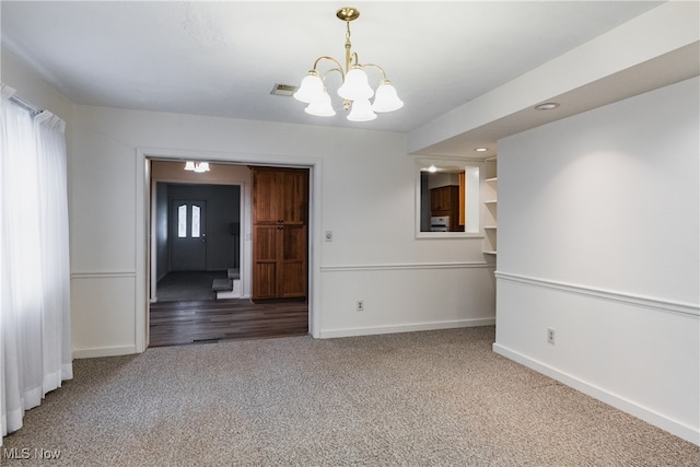 unfurnished room with an inviting chandelier and wood-type flooring