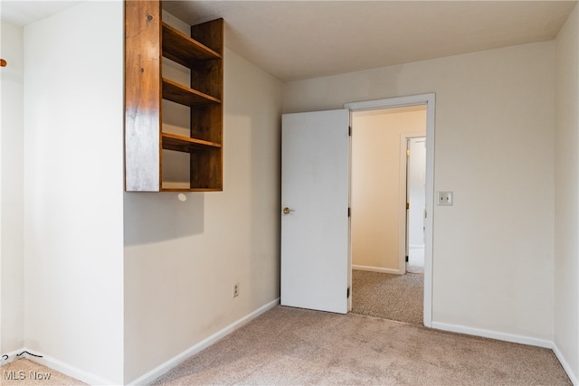 spare room featuring light carpet