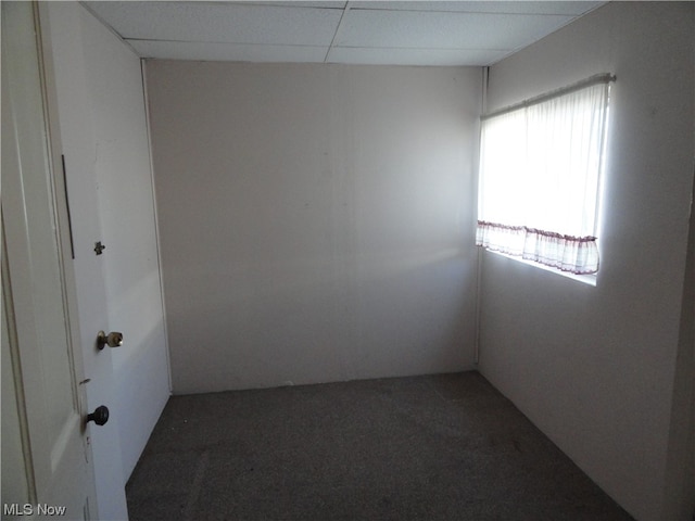 carpeted empty room with a paneled ceiling